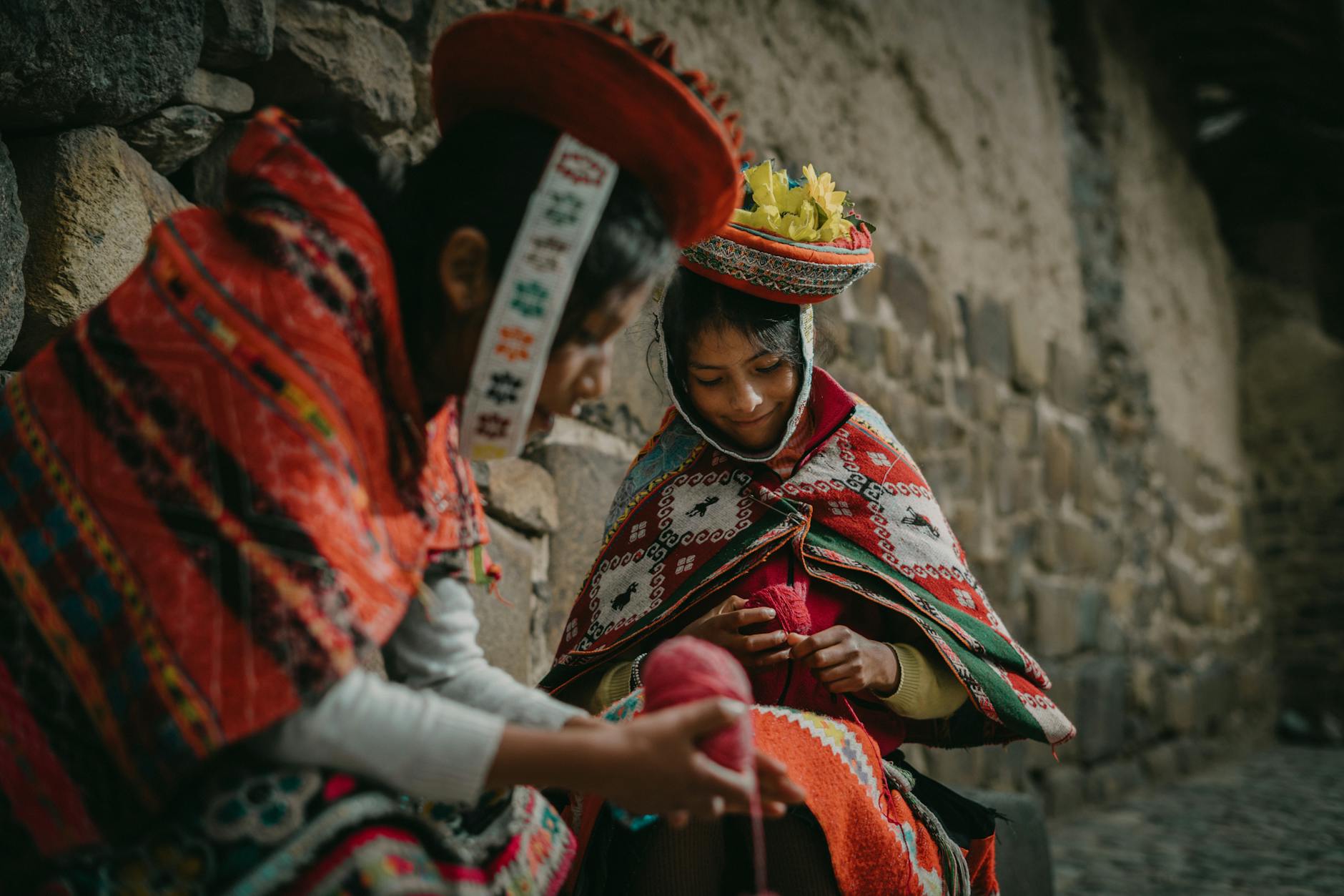 Cusco - Property of: Saraí Carrasco, Peruvian Girls Wearing Traditional Clothing, Sitting by a Wall  - Melhores destinos no Peru