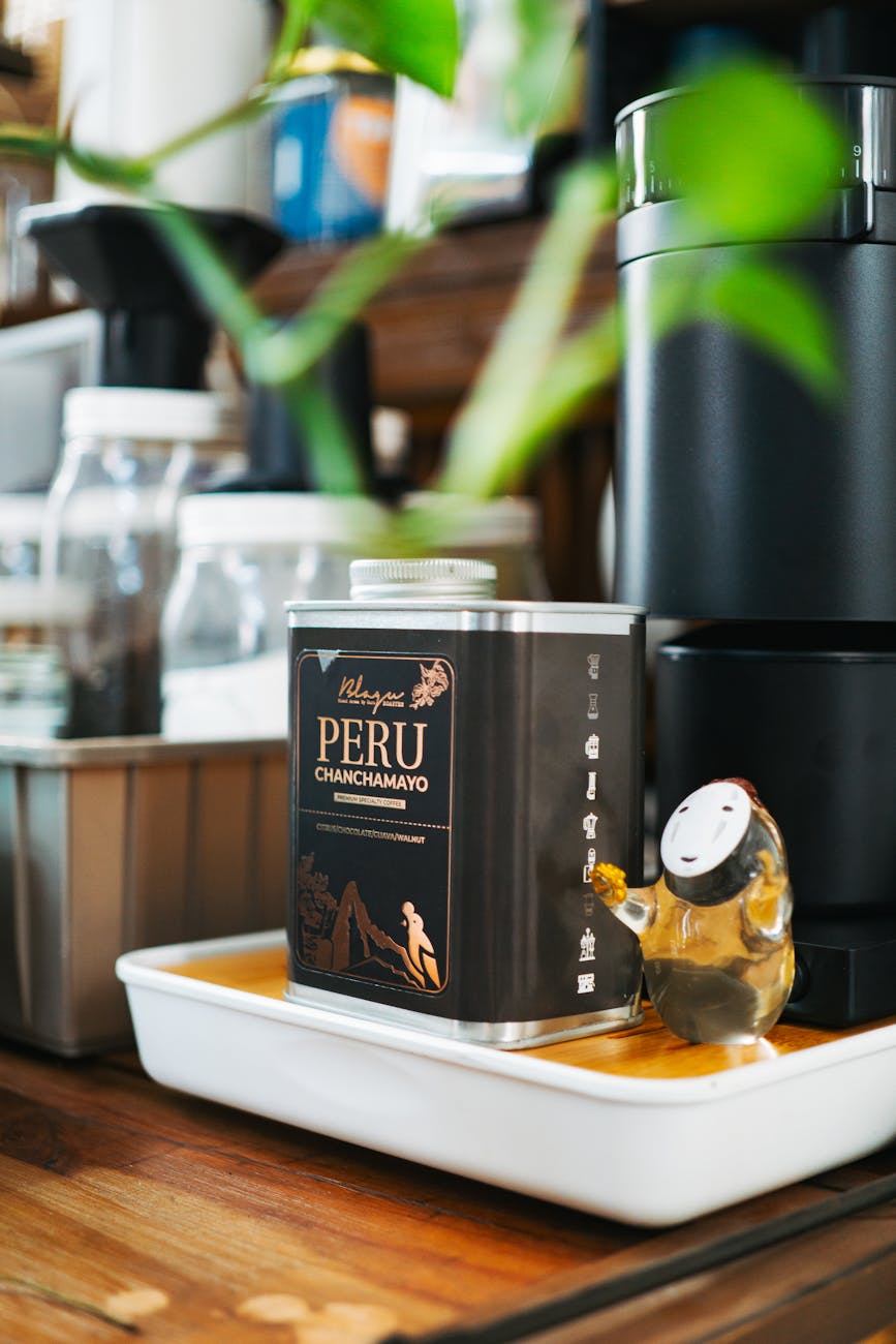 A coffee maker sits on a counter next to a plant  - Comer em Lima