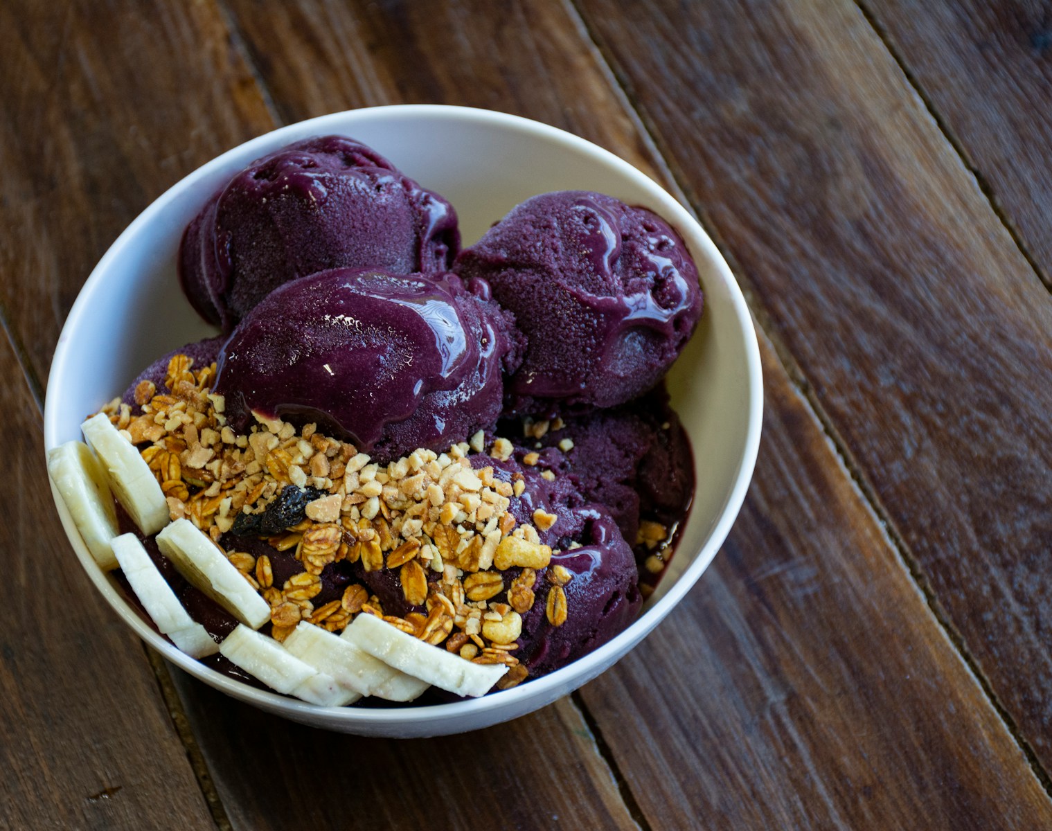 a bowl of ice cream with bananas and granola - Gastronomia Amazônica