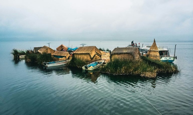 houses between body of water - Passeios no Lago Titicaca