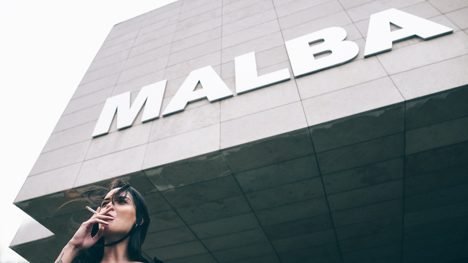 woman taking cigarette near Malba building - Museus Imperdíveis em Buenos Aires