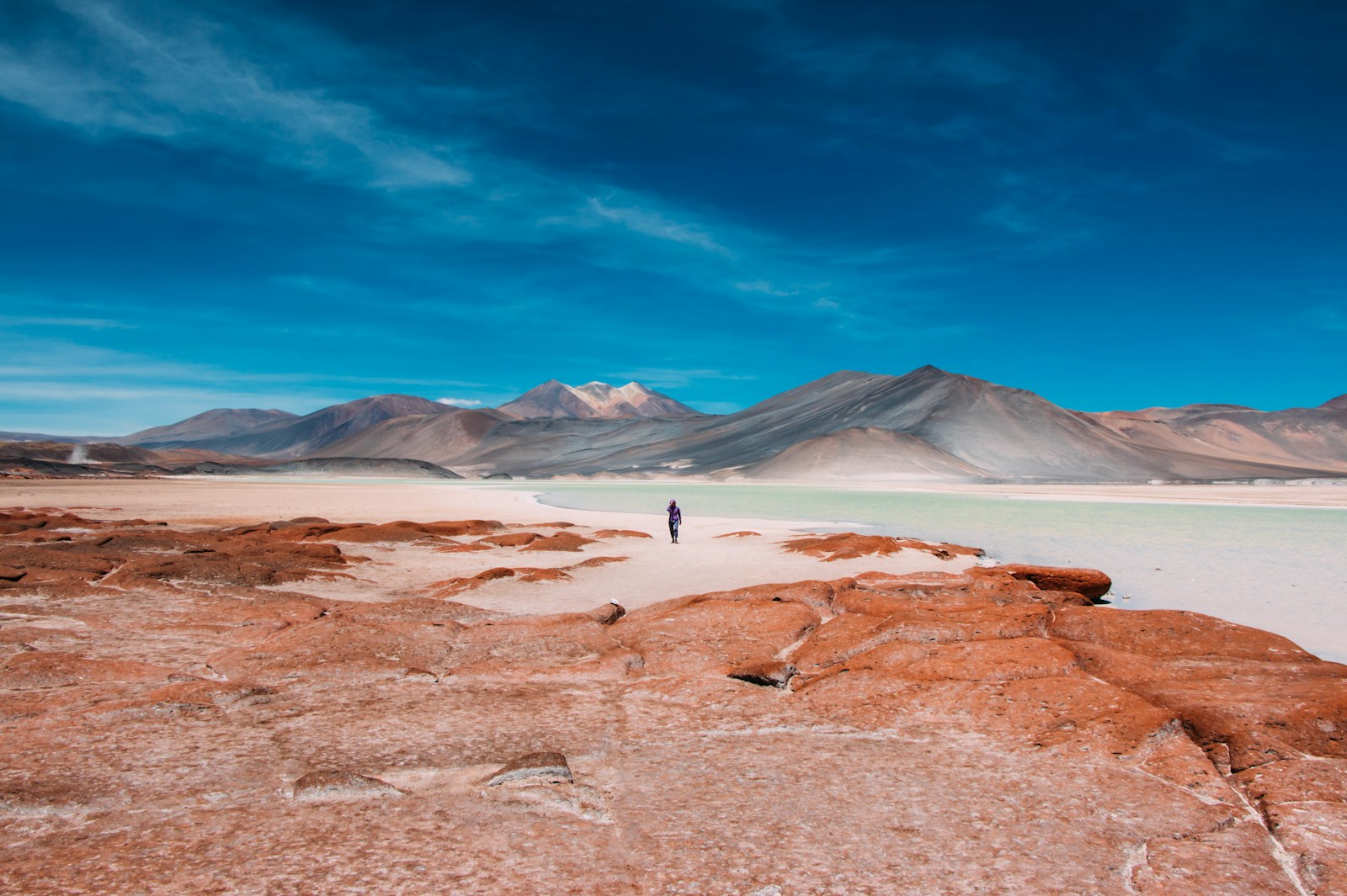 person walking in distance of mountain - Deserto do Atacama