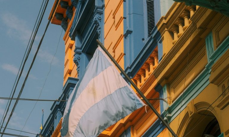 a building with a flag hanging from it's side - Museus Imperdíveis em Buenos Aires