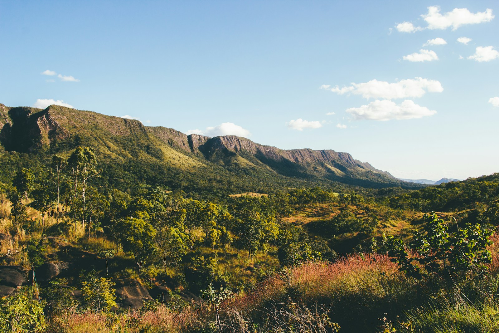 green and brown mountain under blue sky during daytime - Cachoeiras na Chapada dos Veadeiros