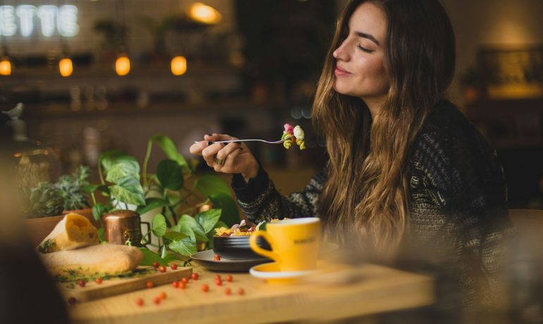 woman holding fork in front table - Cafeterias em Medellín